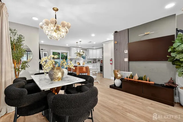a living room with furniture kitchen view and a chandelier
