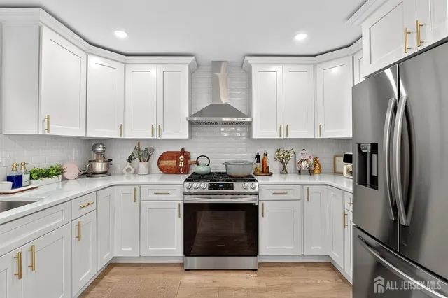 a kitchen with stainless steel appliances granite countertop a refrigerator sink and stove