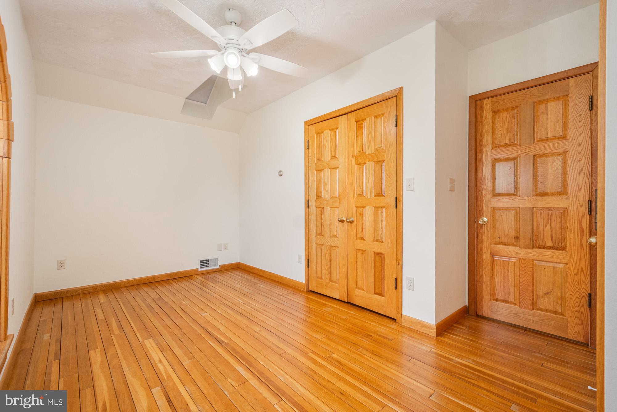 4007 White Rock Road Friendsville, MD 21531 - Photo 31 of 39 an empty room with wooden floor and a ceiling fan