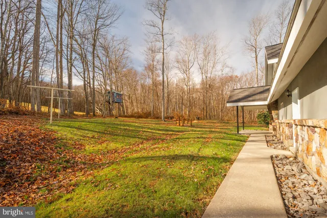 a view of swimming pool with outdoor seating and trees in the background