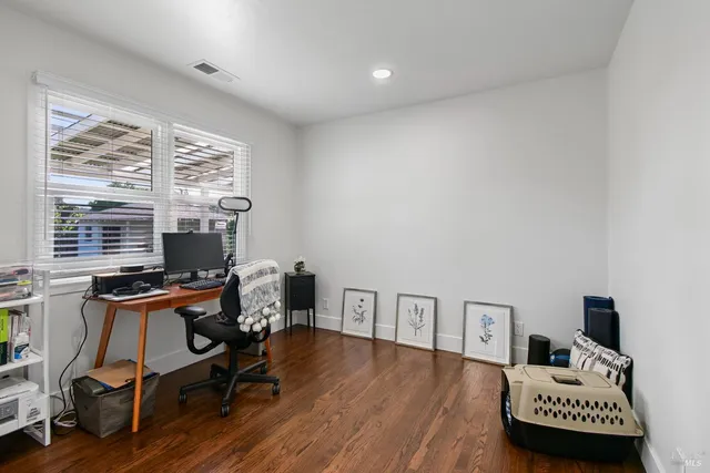 a view of a workspace with furniture and a window