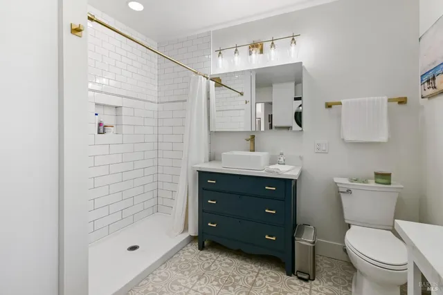 a bathroom with a sink a toilet and shower