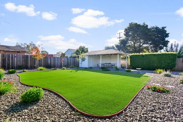 a view of a backyard with a garden and entertaining space