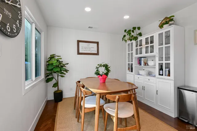 a dining room with furniture and a potted plant