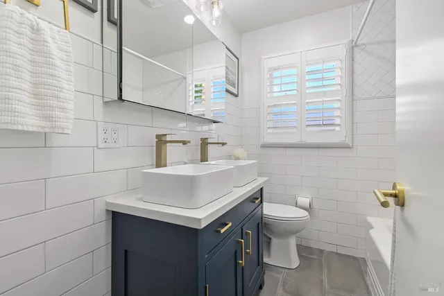 a bathroom with a sink toilet and window