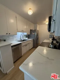 a kitchen with stainless steel appliances a sink stove and cabinets