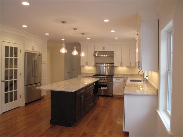 a kitchen with stainless steel appliances granite countertop a refrigerator a stove and a wooden floors