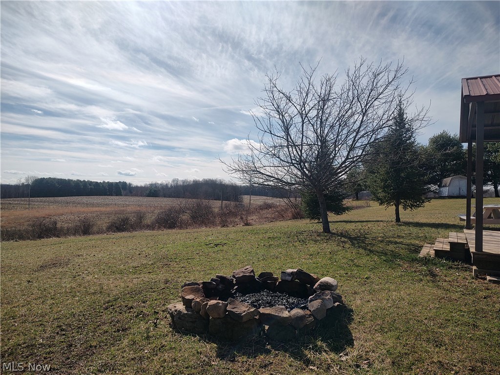 11973 Virtue Road Kimbolton, OH 43749 - Photo 8 of 12 View of grassy yard featuring a fire pit and a view of countryside