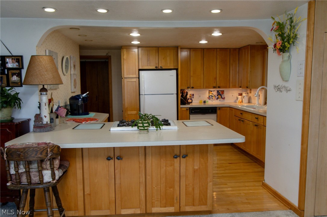 5467 Chapel Road Madison, OH 44057 - Photo 30 of 50 Kitchen featuring light wood cabinetry, recessed lighting, a built-in cooktop island, and light-colored countertops