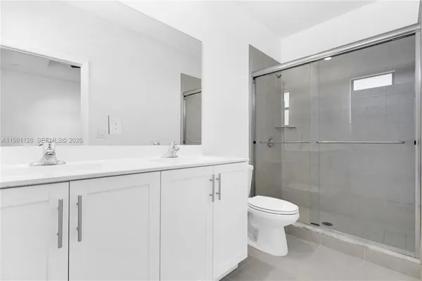 a bathroom with a granite countertop sink a toilet and shower