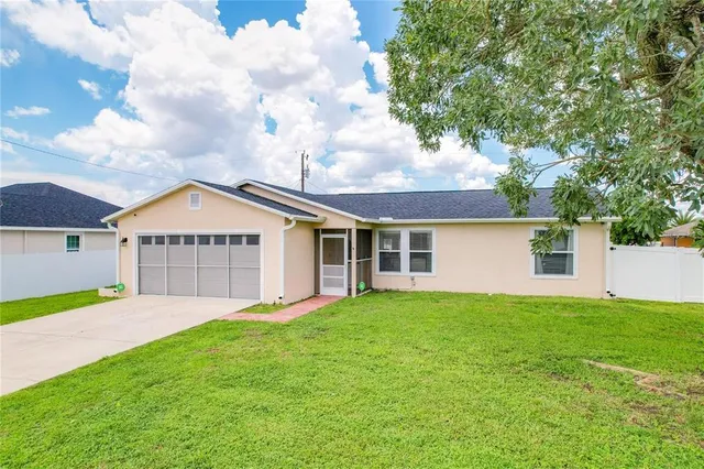 a view of a house with a yard and a large tree