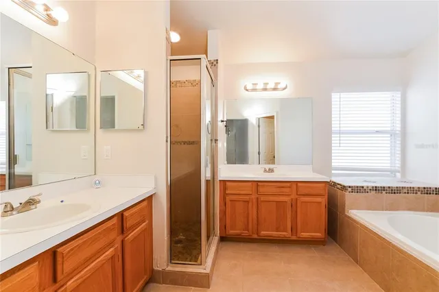 a bathroom with a bathtub double sink and mirror