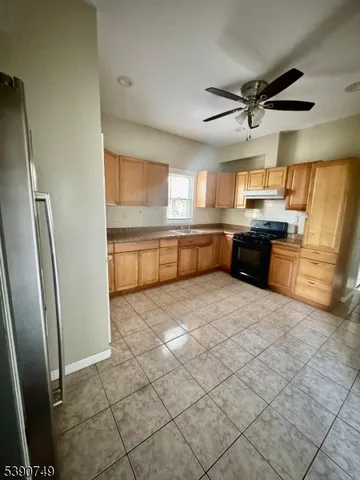a large kitchen with a stove a refrigerator and a sink