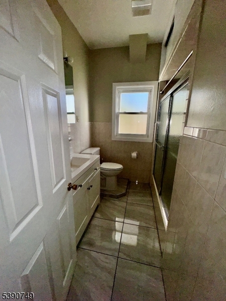 131 Bellevue Street Elizabeth, NJ 07202 - Photo 8 of 16 a bathroom with a sink a toilet and a mirror