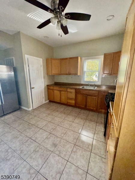 131 Bellevue Street Elizabeth, NJ 07202 - Photo 9 of 16 a large kitchen with a stove a refrigerator a sink dishwasher and wooden cabinets
