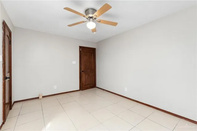 an empty room with a ceiling fan and a window