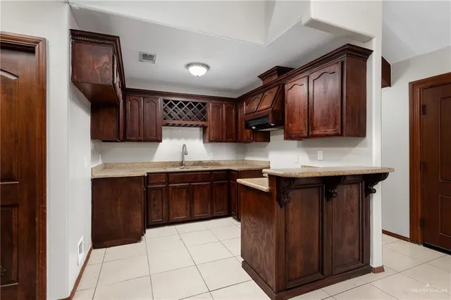 a kitchen with stainless steel appliances granite countertop wooden cabinets a stove top oven a sink and dishwasher
