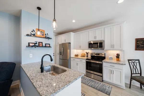 a kitchen with stainless steel appliances a refrigerator stove microwave and sink