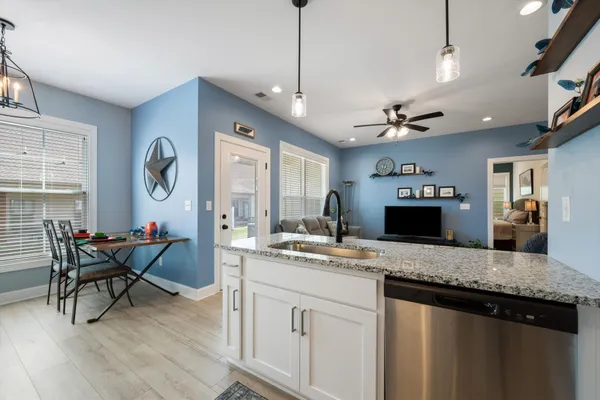 a kitchen that has a lot of cabinets and wooden floor