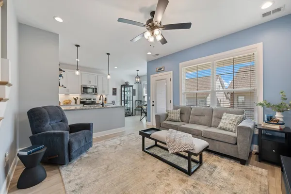 a living room with furniture and a flat screen tv with wooden floor