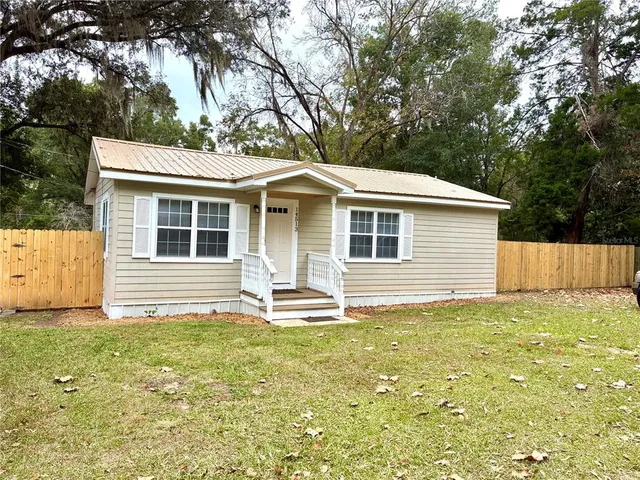 a backyard of a house with table and chairs