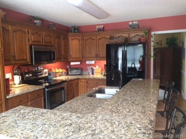 6106 Olive Branch Road Wingate, NC 28174 - Photo 6 of 19 a kitchen with stainless steel appliances granite countertop a stove refrigerator and cabinets