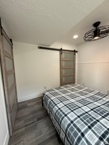 965 North 800 East Springville, UT 84663 - Photo 32 of 46 Bedroom with a barn door, dark wood-style floors, a textured ceiling, and recessed lighting