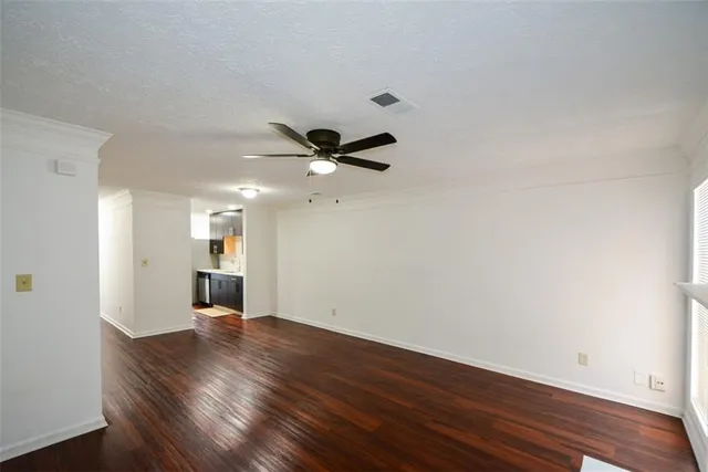 a view of an empty room with wooden floor