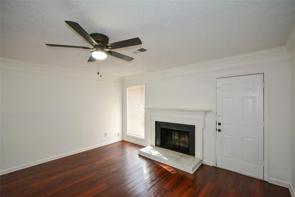2340 Beaver Ruin Road, Unit UN26 Norcross, GA 30071 - Photo 12 of 42 a view of an empty room with wooden floor and a fireplace
