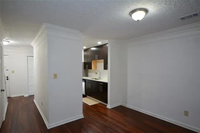 an empty room with wooden floor and cabinet