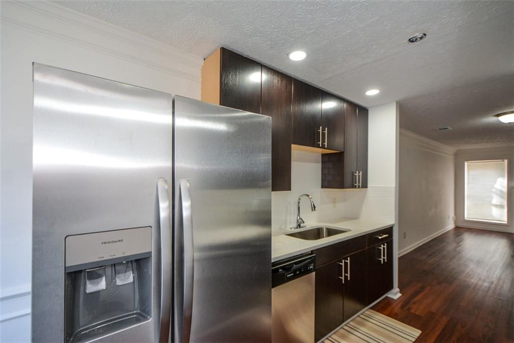 2340 Beaver Ruin Road, Unit UN26 Norcross, GA 30071 - Photo 17 of 42 a kitchen with kitchen island granite countertop stainless steel appliances cabinets a sink and a counter top space