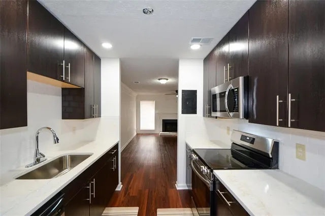 a large kitchen with granite countertop a sink and a stove top oven
