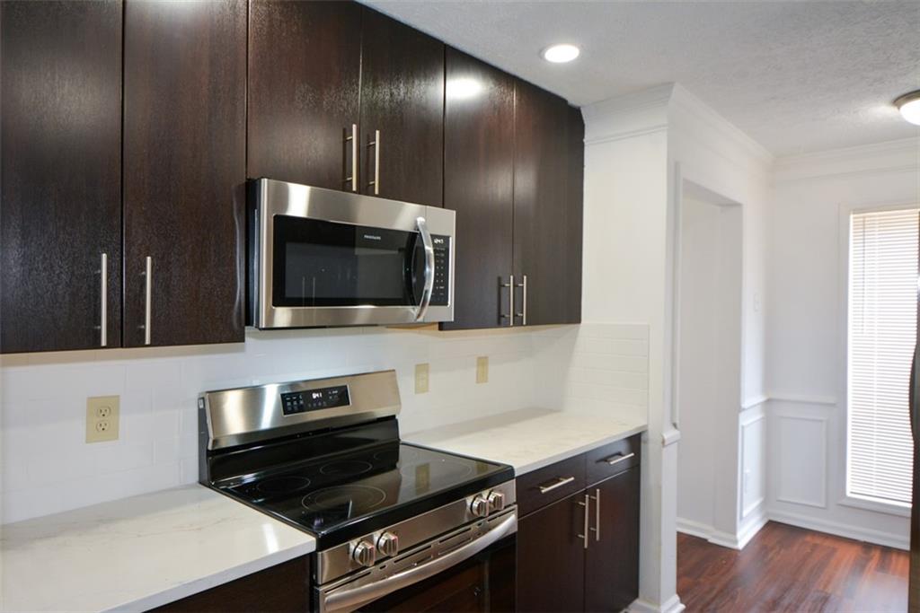 2340 Beaver Ruin Road, Unit UN26 Norcross, GA 30071 - Photo 20 of 42 a kitchen with a stove and a microwave
