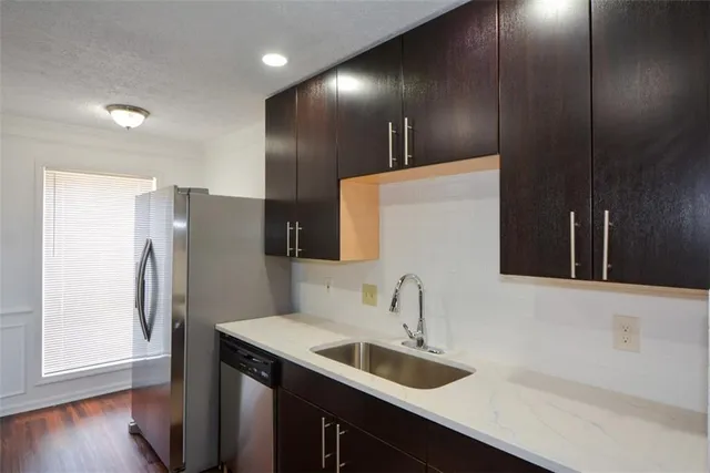 a kitchen with stainless steel appliances a sink and a refrigerator