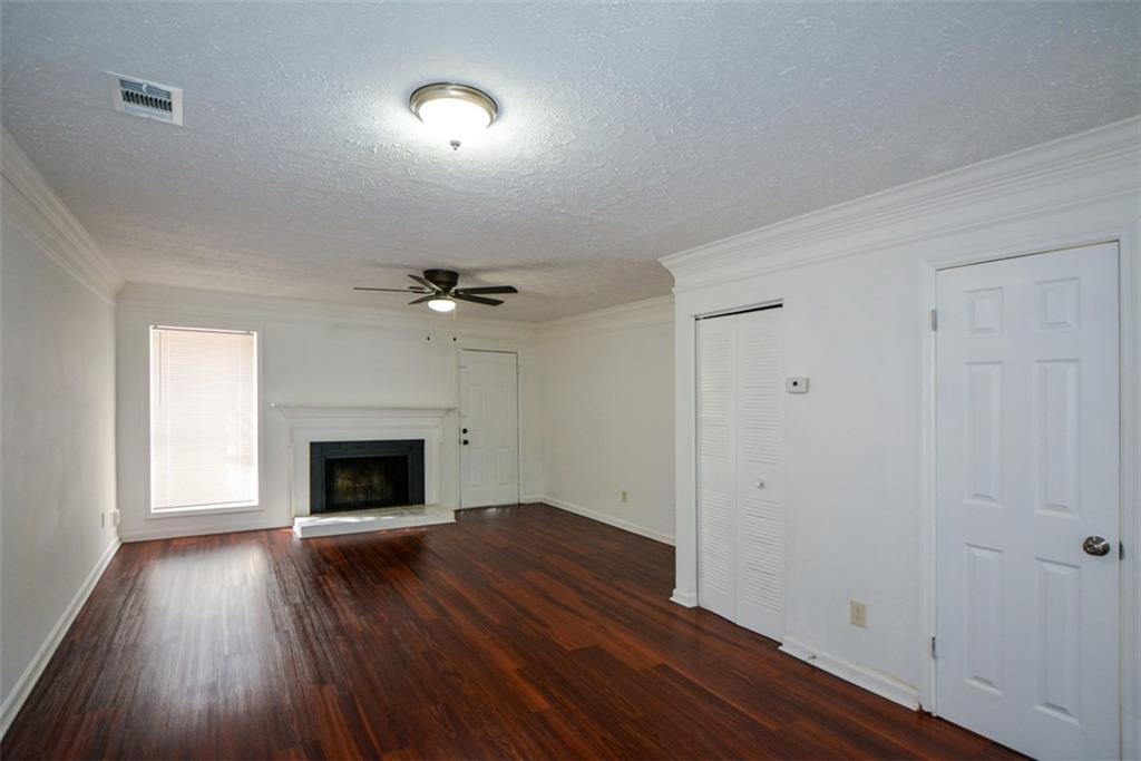 2340 Beaver Ruin Road, Unit UN26 Norcross, GA 30071 - Photo 23 of 42 an empty room with wooden floor a fireplace and windows