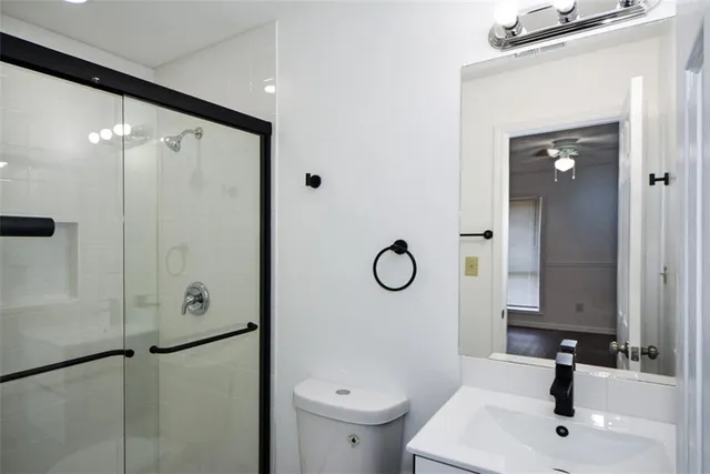 a bathroom with a sink a toilet and shower