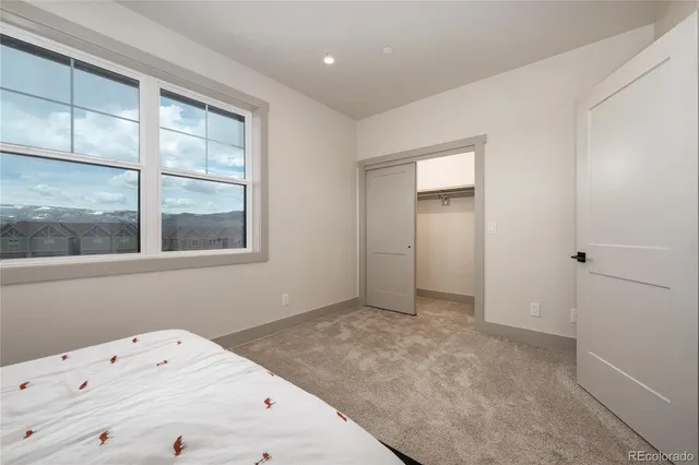 a view of a bedroom with a window and a ceiling fan