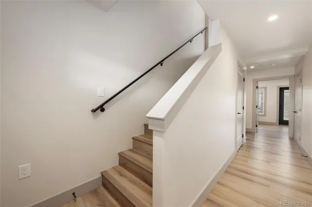 a view of a hallway with wooden floor and staircase