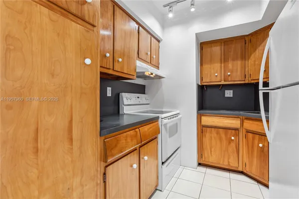 a kitchen with stainless steel appliances granite countertop a refrigerator and a stove top oven