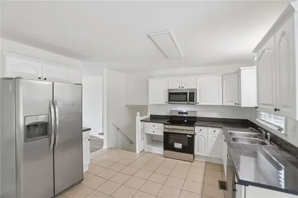 a kitchen with a stove sink and cabinets