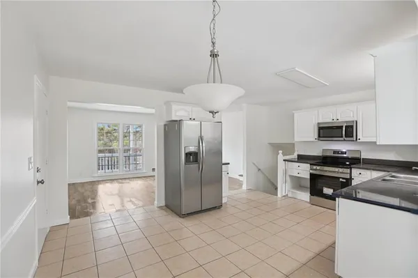 a kitchen with stainless steel appliances granite countertop a stove a refrigerator and a sink