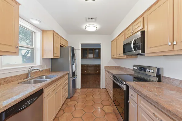 a kitchen with stainless steel appliances granite countertop a sink stove and refrigerator