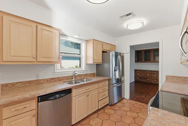 a kitchen with stainless steel appliances granite countertop a sink stove and refrigerator