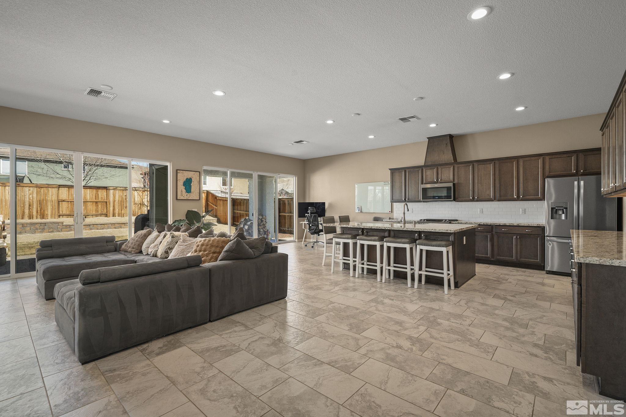 2895 Ethelinda Way Reno, NV 89521 - Photo 3 of 30 a living room with furniture a large window and a counter top space