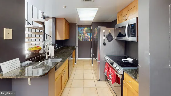 a kitchen with stainless steel appliances granite countertop a stove a sink and a refrigerator