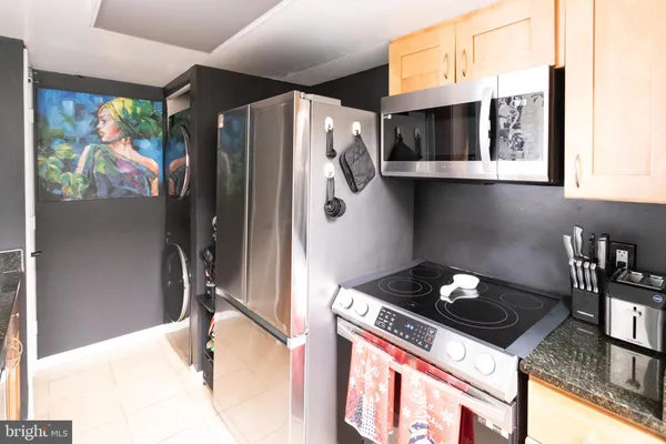 a kitchen with stainless steel appliances granite countertop a refrigerator and a stove