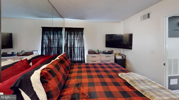 a bedroom with a bed and a flat screen tv