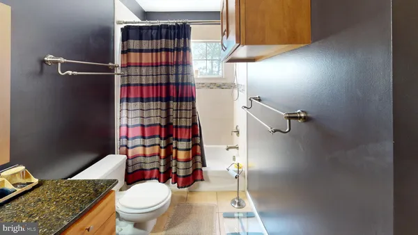 a bathroom with a granite countertop toilet and a shower