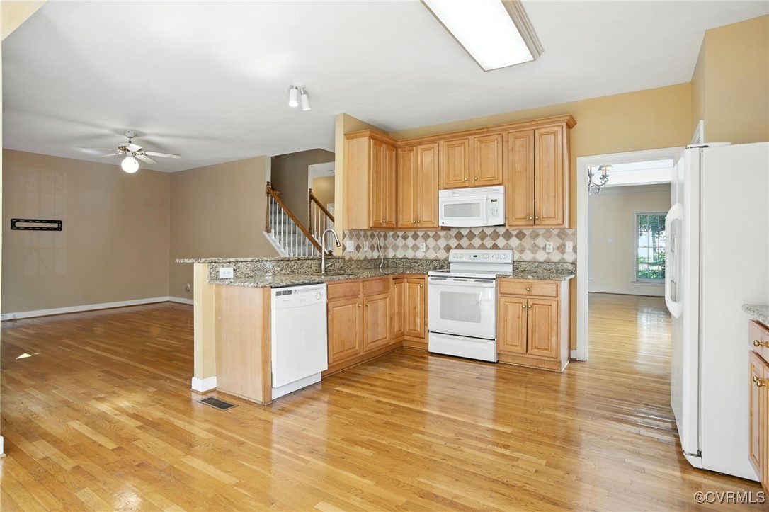 8248 Hampton Arbor Circle Chesterfield, VA 23832 - Photo 6 of 41 a kitchen with granite countertop a stove a sink and white cabinets with wooden floor