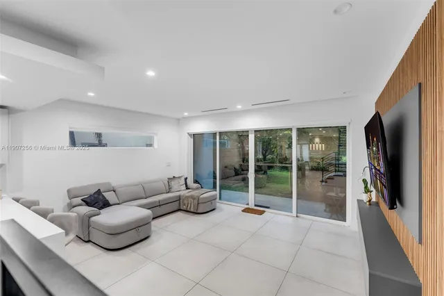a living room with furniture potted plant and large windows